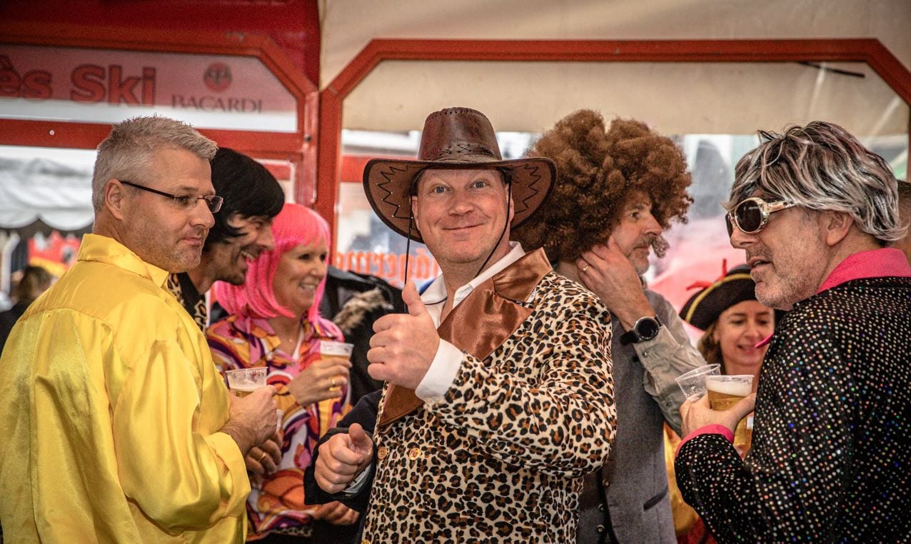 Feestgangers met een biertje in de hand in de Schirmbar